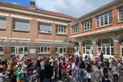 des enfants en pleine chorégraphie dans la cours de l'école Henri Cahn en 2023 pour la fête du Printemps. - Agrandir l'image 7 sur 9, fenêtre modale