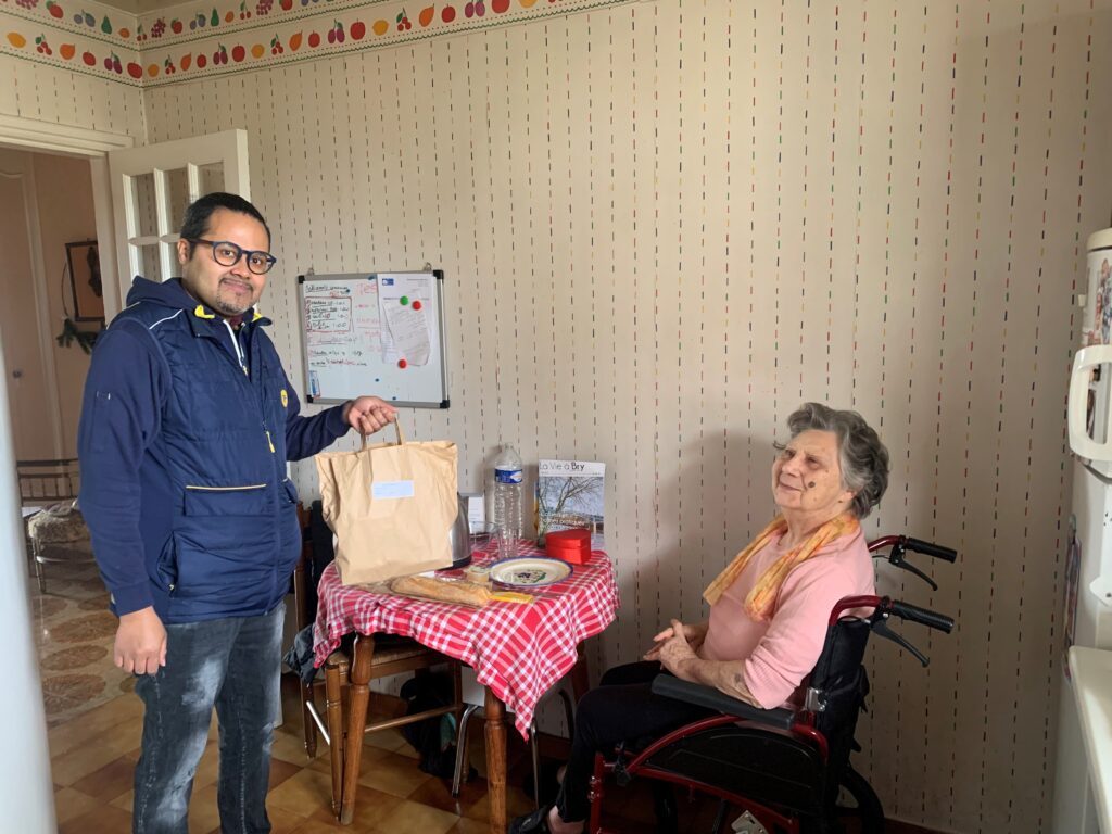 Homme qui tient un sac posé sur la table d'une femme en fauteuil roulant - Agrandir l'image, fenêtre modale