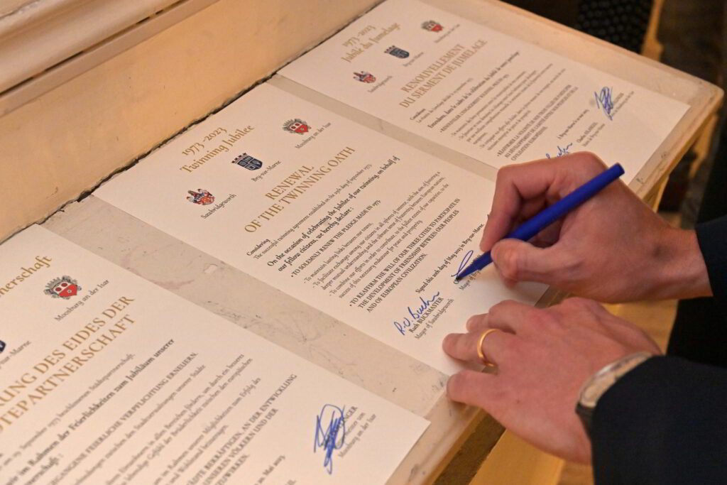 Vue sur les mains d'une personne qui signe un document  - Agrandir l'image, fenêtre modale