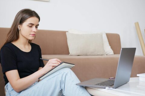 Jeune fille qui écrit devant un ordinateur