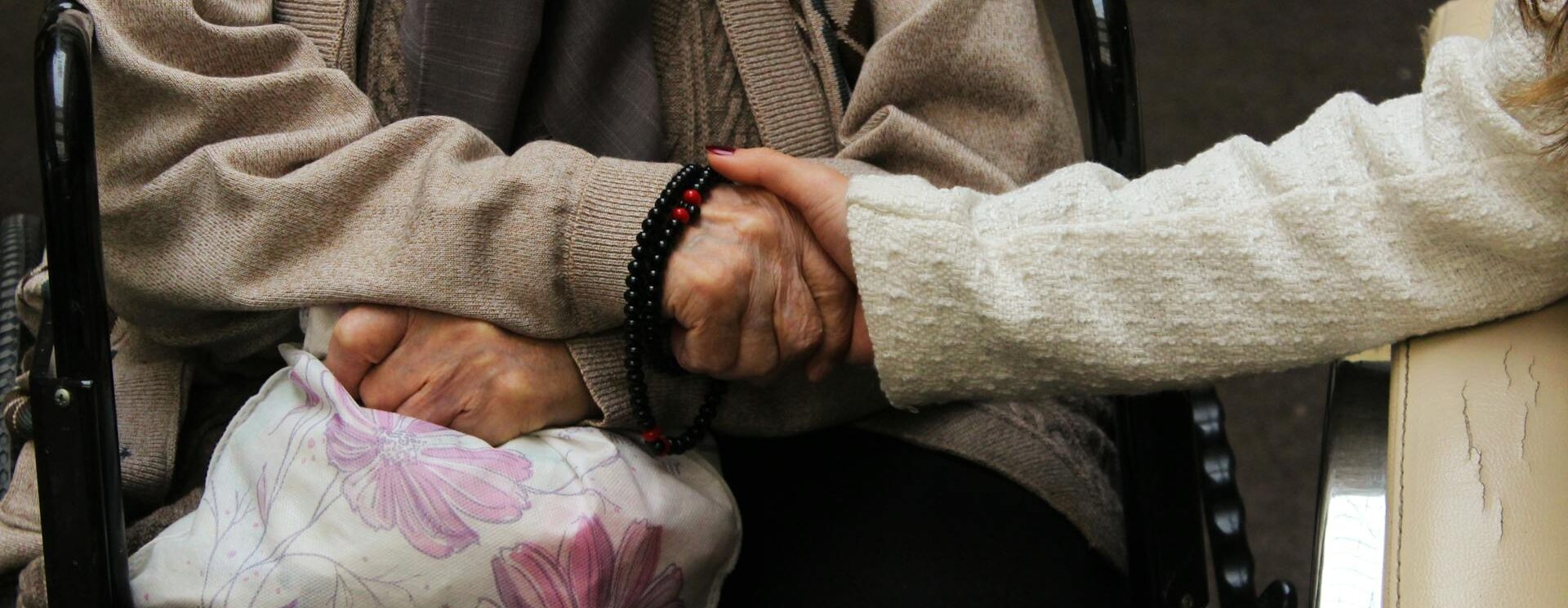 Main qui tient la main d'une personne âgée