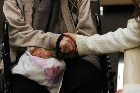 Main qui tient la main d'une personne âgée