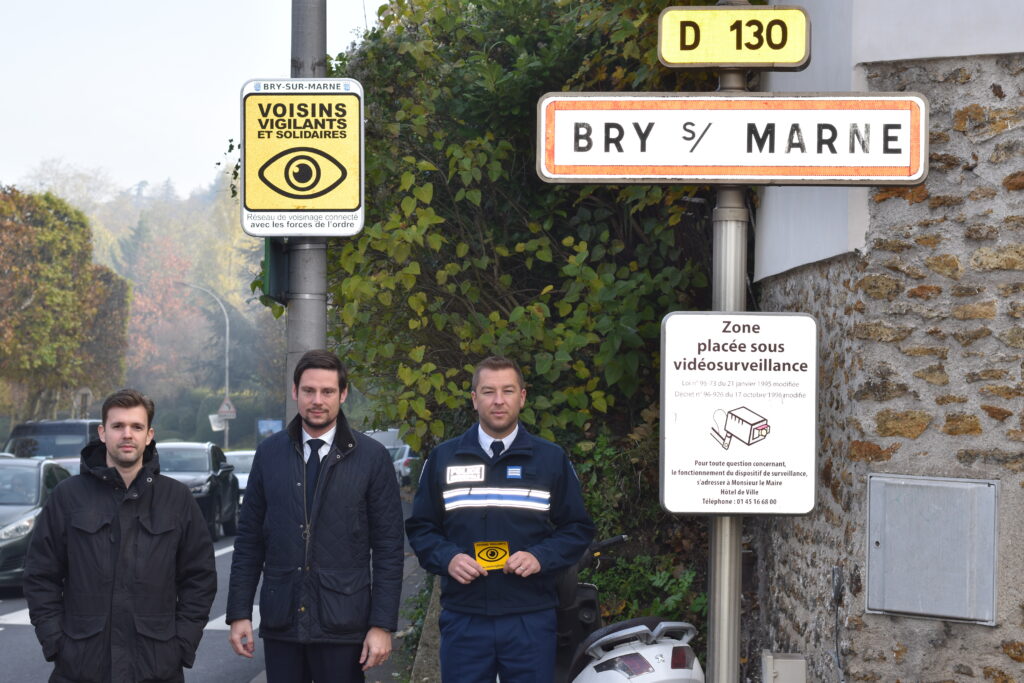 Monsieur le Maire, un membre du Conseil Municipal et un policier devant le panneau de la ville de Bry-sur-Marne - Agrandir l'image, fenêtre modale