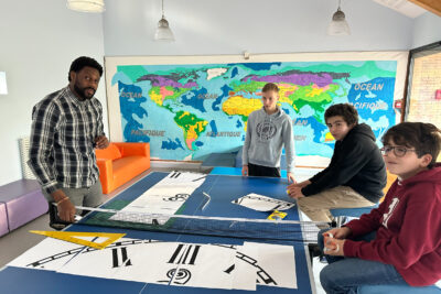 Jeunes devant une table de ping pong sur laquelle sont posés des dessins - Agrandir l'image 2 sur 12, fenêtre modale