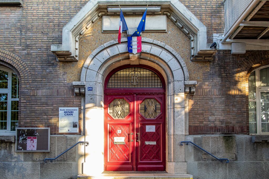 La grande porte rouge, de style ancien, assez imposante, de l'école Henri Cahn. - Agrandir l'image, fenêtre modale