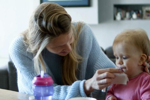 Femme qui essuie la bouche d'un bébé
