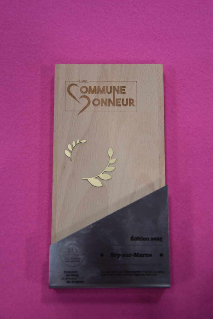 Trophée en bois sur lequel il est inscrit "Label Commune d'honneur, édition 2023, Bry-sur-Marne" - Agrandir l'image, fenêtre modale