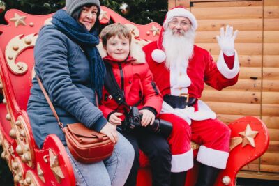 Père Noël qui prend une photo avec une mère et son enfant dans son traineau - Agrandir l'image 10 sur 24, fenêtre modale