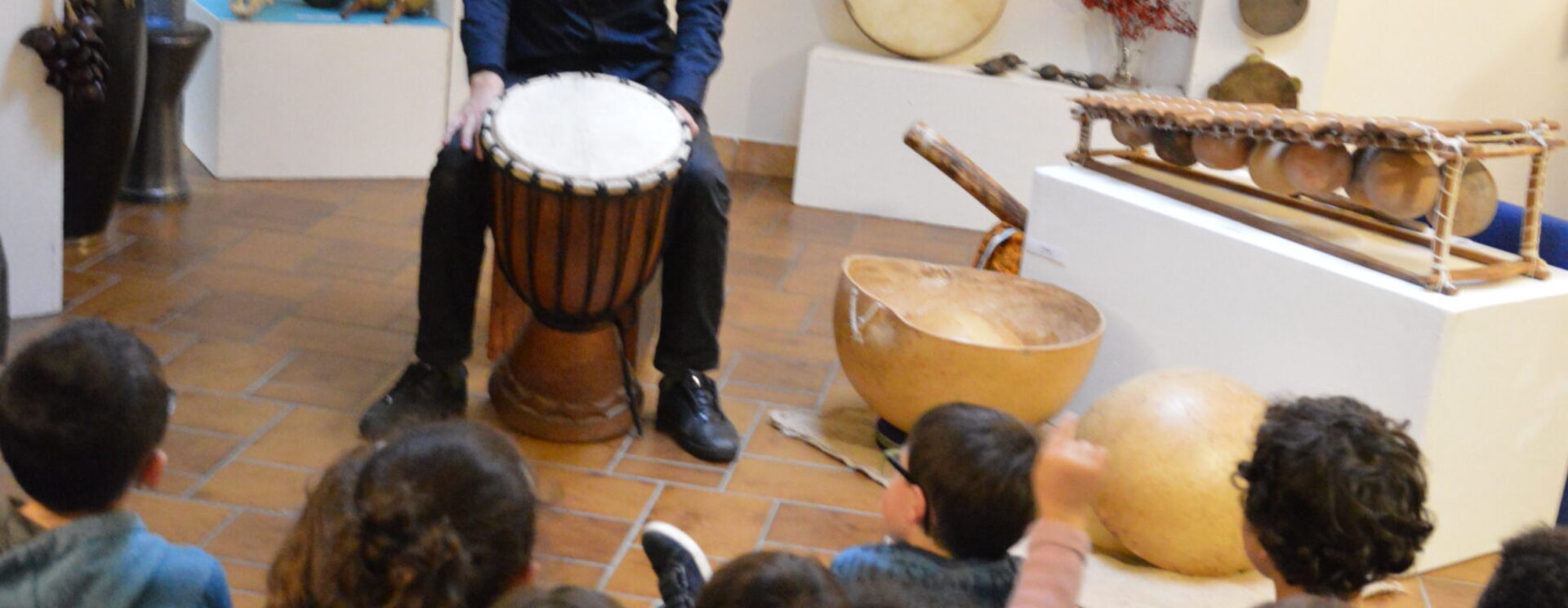 Enfants qui regardent un homme qui joue d'un instrument