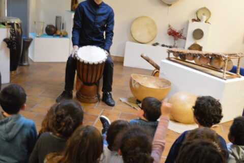Enfants qui regardent un homme qui joue d'un instrument
