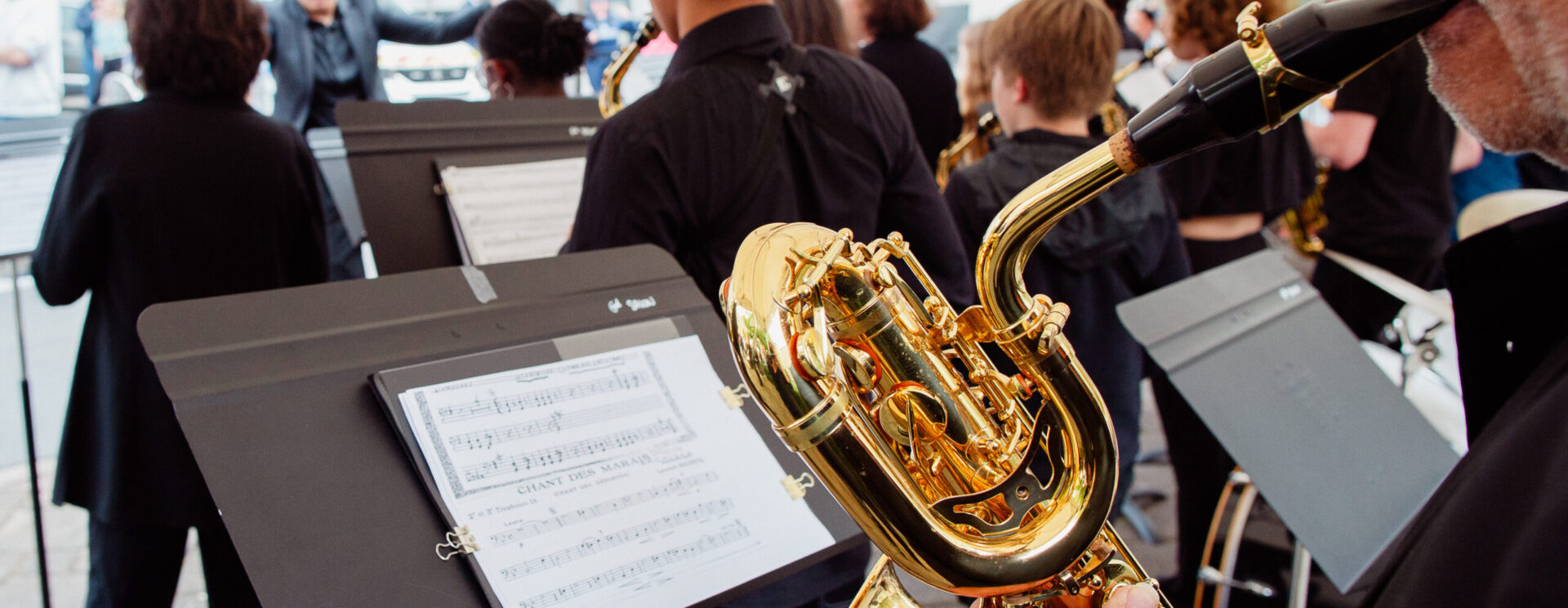 Homme qui joue du saxophone devant un pupitre