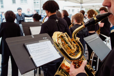 Homme qui joue du saxophone devant un pupitre