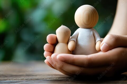 Mains d'enfant qui tiennent des jouets en bois