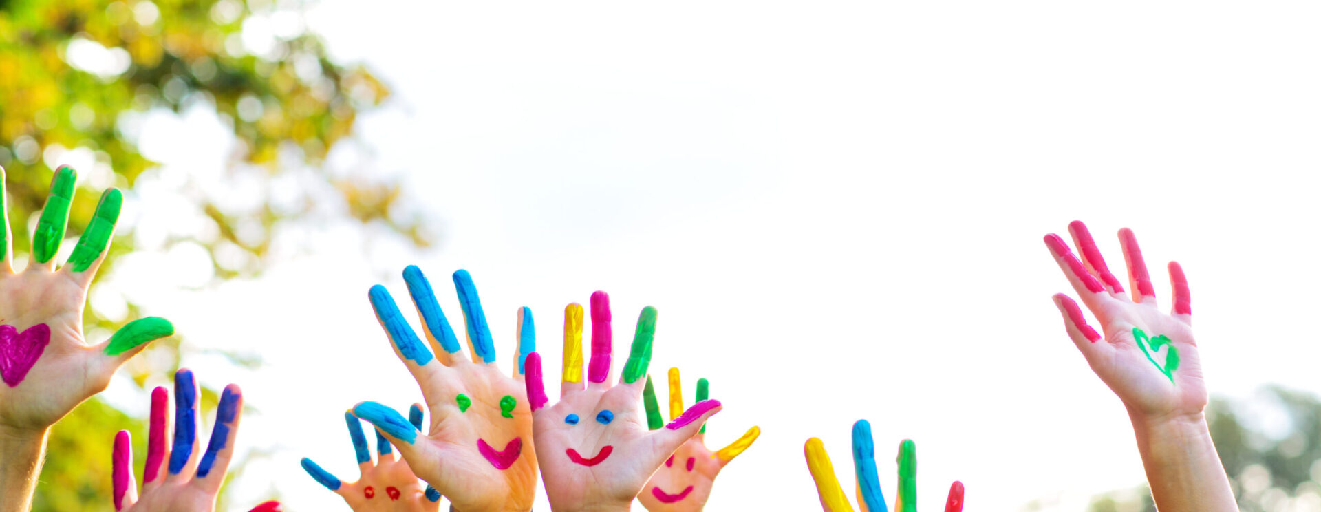 Mains d'enfants avec de la peinture en forme de visages