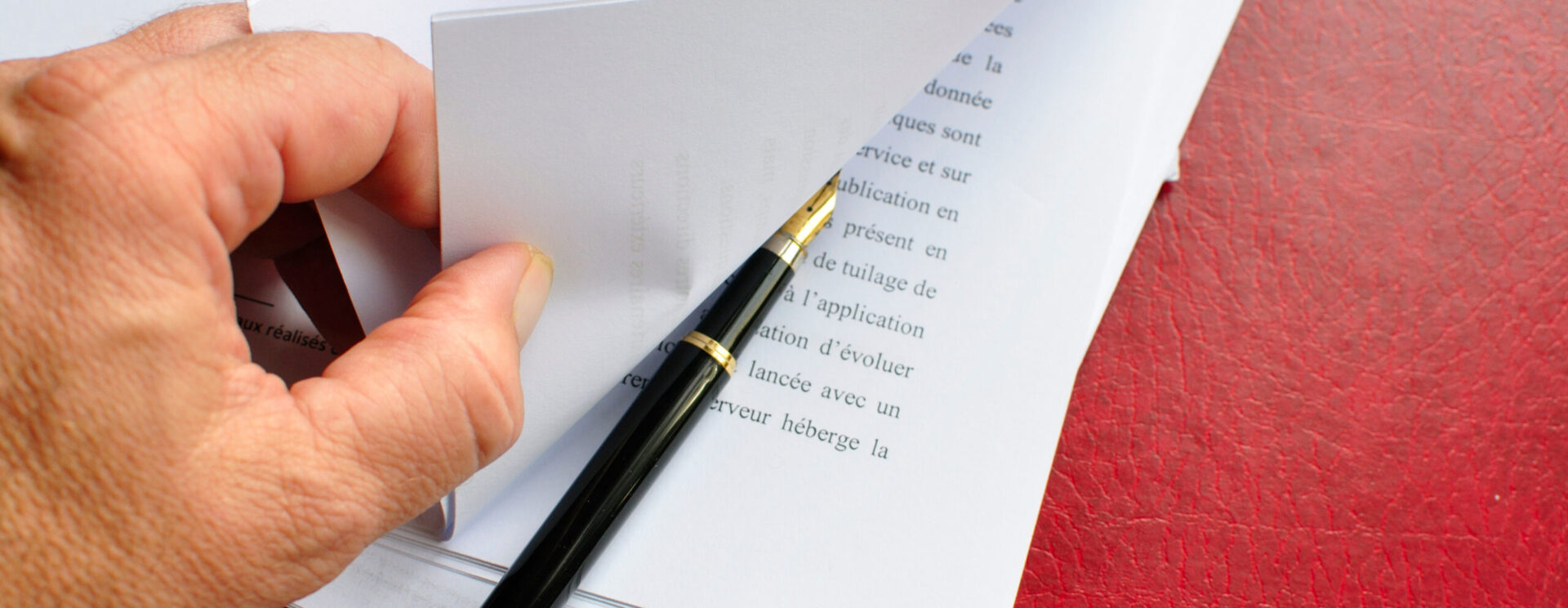 Une main feuilletant des documents