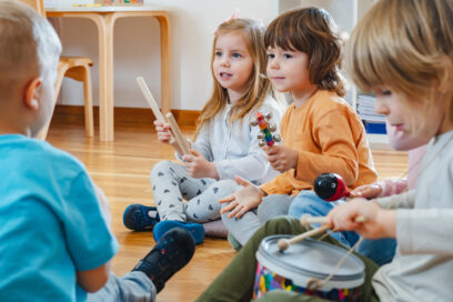 Des enfants assis par terre qui découvrent des instruments de musique - Agrandir l'image, fenêtre modale